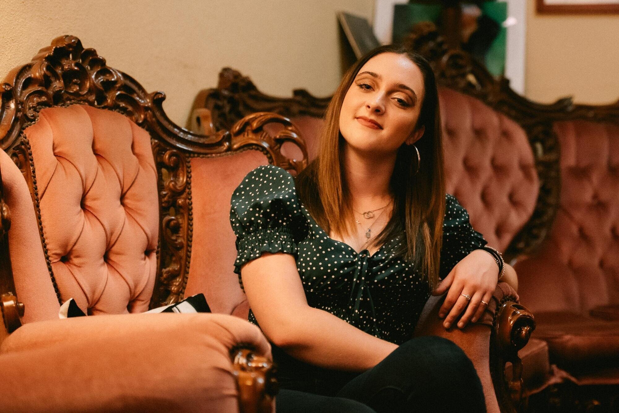Piper Butcher in polka dot top on the sofa